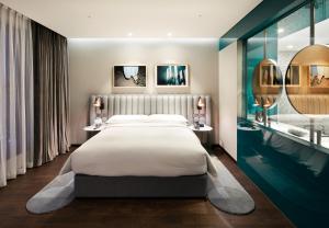 a bedroom with a large bed and a bathroom at RYSE, Autograph Collection, Seoul in Seoul