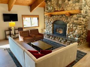 a living room with a couch and a stone fireplace at AmericInn by Wyndham Tofte Near Lake Superior in Tofte