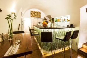 a kitchen with a bar with chairs and a table at Hotel U Zlateho jelena in Prague