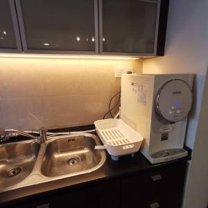 a kitchen counter with a sink and a hair dryer at SunwayLagoonFamilySuite-4-7pax-Netflix-Balcony-Super Fast Internet in Kampong Penaga