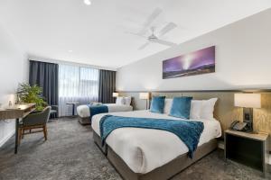 a hotel room with two beds and a desk at The Remington Orange in Orange