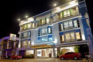 un edificio con coches aparcados delante de él por la noche en Crown Regency Hotel Makati en Manila