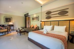 a hotel room with a bed and a desk at Sanctoo Suites & Villas in Sukawati