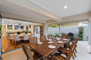 uma sala de jantar e sala de estar com mesa e cadeiras em Sorrento Waterfront Retreat,Pool em Gold Coast
