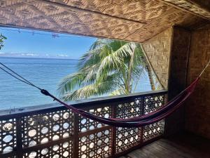 hamaca en una habitación con vistas al océano en Borbon's Treehouse By the Sea en Mambajao