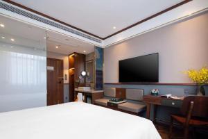 a hotel room with a bed and a television at Nostalgia S Hotel - Beijing Xidan Financial Street in Beijing