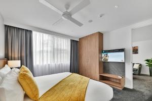 a bedroom with a bed and a flat screen tv at The Remington Orange in Orange