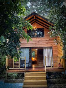 Cabaña de madera con escalera que conduce a un porche en Vital Ecohotel Cabañas en Guarne
