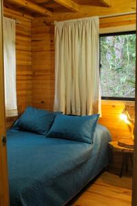 a bedroom with a bed with a window and a bed sidx sidx sidx at Vital Ecohotel Cabañas in Guarne
