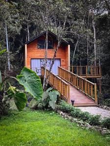 Cabaña de madera con rampa que conduce a una terraza en Vital Ecohotel Cabañas, en Guarne