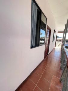a hallway with a window and a tiled floor at Mochis in Quepos