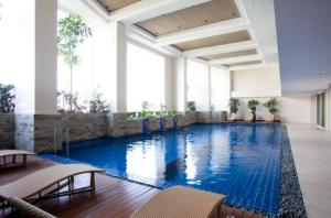 a large swimming pool with blue water in a building at Sky Staycation KL Greenbelt, Isabel's Makati Rooms in Manila