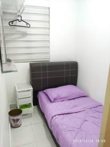 - un petit lit dans une chambre avec une couverture violette dans l'établissement Lavender home, à Nilai