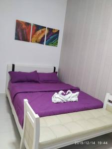 - un lit avec des draps violets et une couverture violette dans l'établissement Lavender home, à Nilai
