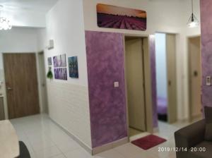 Cette chambre est dotée de murs violets et d'une peinture murale. dans l'établissement Lavender home, à Nilai