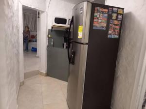 麥德林的住宿－Pioneros Poblado casa tradición，厨房配有黑色冰箱,配有微波炉