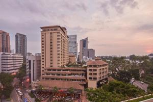 a city skyline with a tall building in the foreground at Orchard Rendezvous Hotel by Far East Hospitality in Singapore
