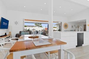 a kitchen and dining room with a table and chairs at Mooloolaba Oasis 4bd Home, Pool in Mooloolaba