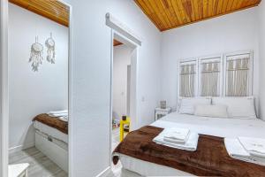una camera bianca con letto e specchio di Alfama Rose Apartment a Lisbona
