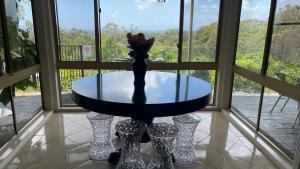 uma mesa com um vaso na frente de uma janela em Como Guest Suite em Gold Coast