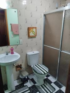 uma casa de banho com um WC, um lavatório e um chuveiro em Apartamento no condomínio Mediterranée- 3 quadras do mar- 1 dormitório em Capão Novo em Capão da Canoa