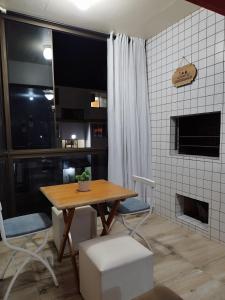 a dining room with a table and a fireplace at Apartamento no condomínio Mediterranée- 3 quadras do mar- 1 dormitório em Capão Novo in Capão da Canoa