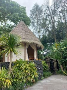 a small hut with a straw roof in a garden at Geopark Village & Spa in Kintamani