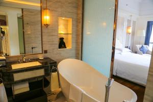 Shenzhen Dayhello international Hotel (Baoan) في باوان: حمام مع حوض ومغسلة وسرير