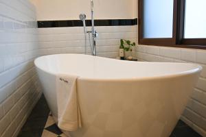 a bath tub in a bathroom with a window at Villa Toscana ValQuirico Lofts & Suites Hotel Boutique in Santeagueda