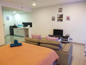 uma sala de estar com um sofá e uma mesa em TREFOIL@SETIA CITY, STUDIO UNIT,HOMESTAY em Shah Alam