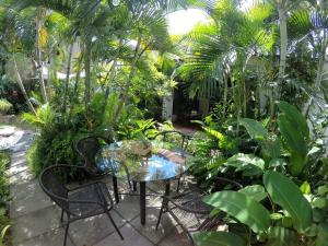 um pátio com uma mesa e cadeiras num jardim em Cinco Hotel B&B em San Salvador