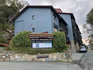 una casa azul con un cartel delante en Ski, Mtn Bike or Hike from the heart of Thredbo, en Thredbo