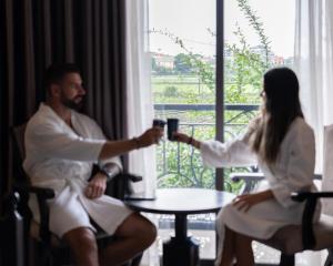a man and woman in white robes holding drinks at Lalita Boutique Hotel & Spa Ninh Binh in Ninh Binh