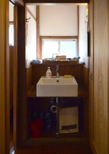 a bathroom with a sink and a window at ZOKUIJINKAN GUESTHOUSe 続異人館 in Arita