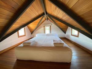 a large white bed in a attic room with windows at Tiny House, La Candelaria in Luján