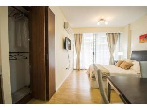 1 dormitorio con cama, mesa y TV en Casa ivana 1 en Buenos Aires