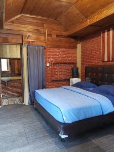 a large bed in a room with a brick wall at Canyon Jungle Stay in Bukittinggi