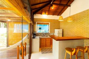 a kitchen with a counter and chairs in a room at Vila Marina in Arraial d'Ajuda
