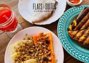 a table with plates of food and a plate of bread at NOVIDADE FLATS COMFORT na Vila de São Jorge - Chapada dos Veadeiros in Sao Jorge