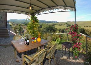 - une table en bois avec des bouteilles de vin sur la terrasse dans l'établissement Agriturismo Il Noce, à Orciatico