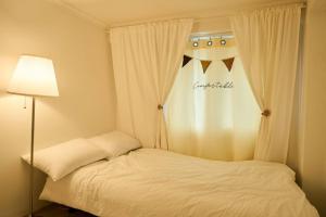 een slaapkamer met een wit bed en een lamp bij 3 rooms, Hongdae, Shinchon unshared Villa in Seoul