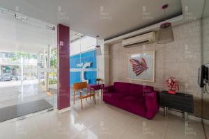 un soggiorno con un divano viola e un tavolo di RedLiving Apartemen Aeropolis - Ivan Tower AR1 a Tangerang