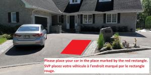 een auto geparkeerd voor een huis met een rood tapijt bij Appartement près des Plaines d'Abraham in Québec