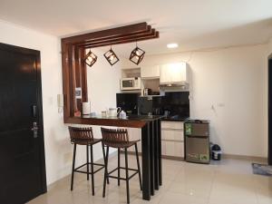 cocina con encimera y taburetes en una habitación en Confortable y Moderno Studio en Santa Cruz de la Sierra