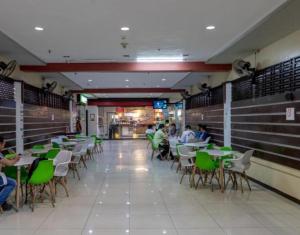 un restaurante con gente sentada en mesas y sillas en Check Inn Bacolod by RedDoorz, en Bacolod