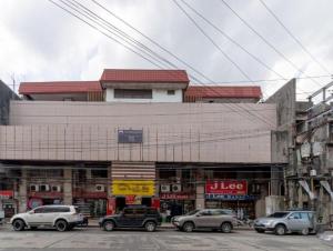 um edifício com carros estacionados em frente em Check Inn Bacolod by RedDoorz em Bacolod