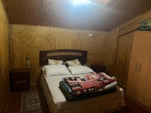 um quarto com uma cama e uma cabeceira em madeira em Cabaña Quillaipe orilla del mar em Puerto Montt