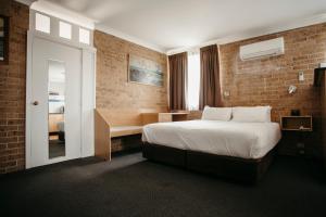 a hotel room with a bed and a desk at Colonial Motel Richmond in Richmond