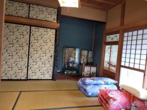 salon z niebieskimi ścianami i oknami oraz kanapą w obiekcie INASHIKI NEST w mieście Inashiki