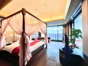 a bedroom with a canopy bed with a view of the ocean at SKY Tower Sweet 4 Beppu, Resort Love Hotel in Beppu